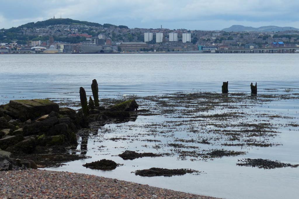 A wide shot of the shoreline near Dundee, with the city visible on the far shore