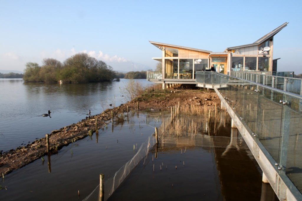 Attenborough Nature Reserve Visitor Centre, built at the end of a pier and surrounded by still water and aquatic foliage