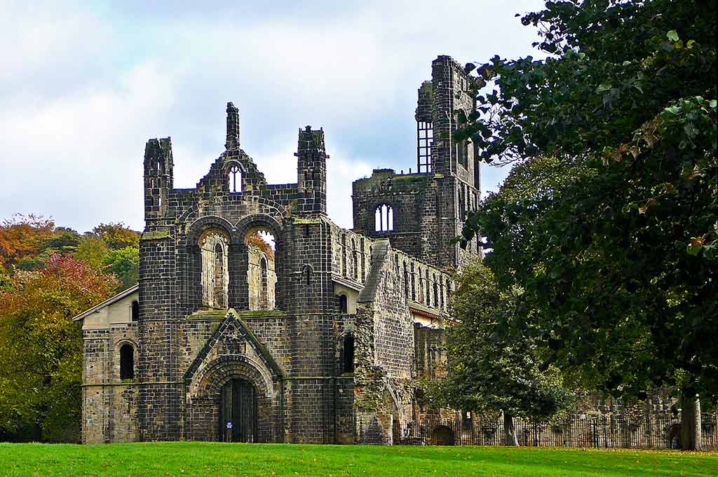 Kirkstall Abbey, a large old stone church, stands in the middle of a green field