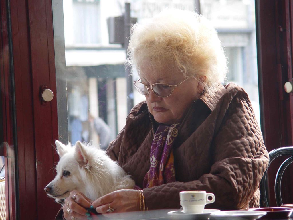 older woman and dog in a coffee shop